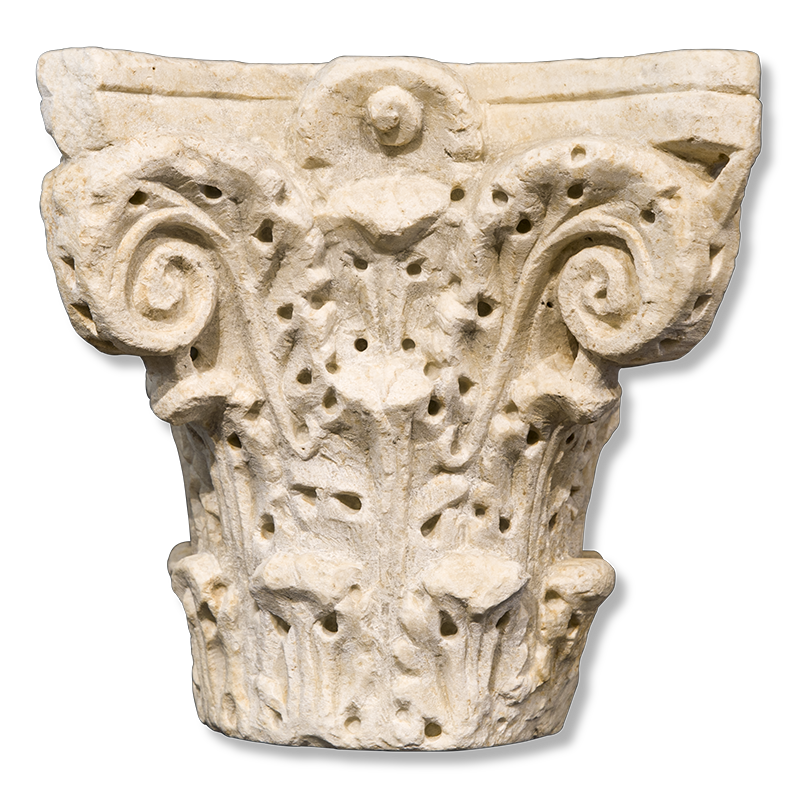 The topmost part of a stone column carved with corner scrolls and vegetal ornament.