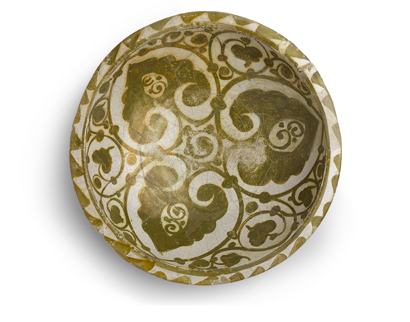 A deep round dish decorated with vegetal ornament, include three large foliar forms at the center.