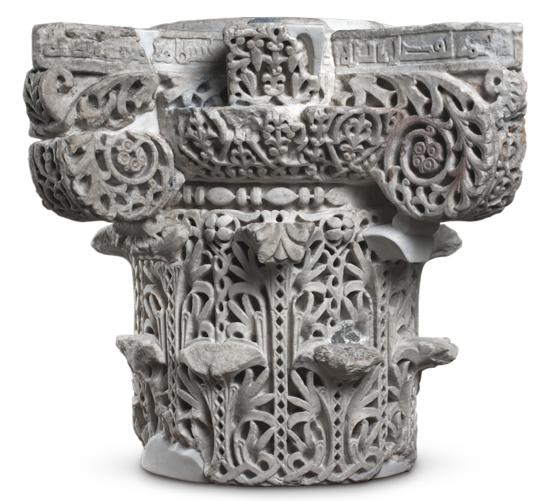 The topmost part of a stone column carved with S-scrolls, stylized acanthus leaves, and interstitial geometric designs.