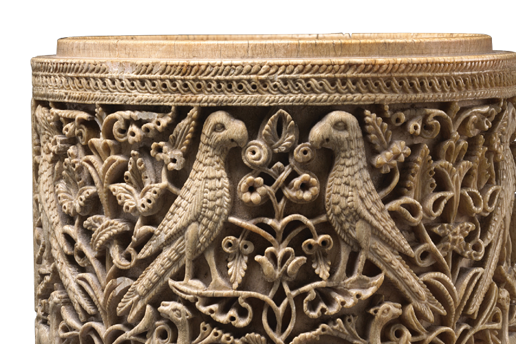 An open cylindrical container decorated with animal and vegetal ornament in relief.